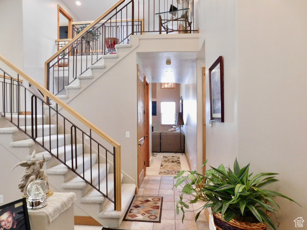Stairs featuring a towering ceiling and tile patterned floors