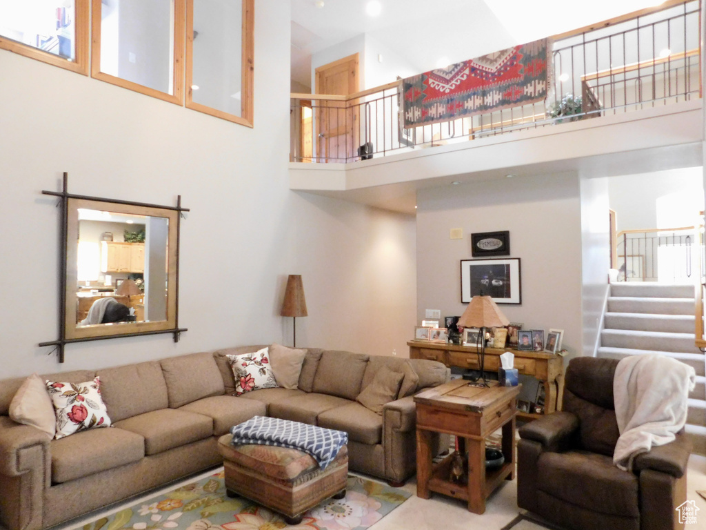 Living area featuring a towering ceiling and stairway