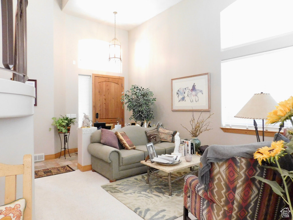 Carpeted living area with a towering ceiling and baseboards