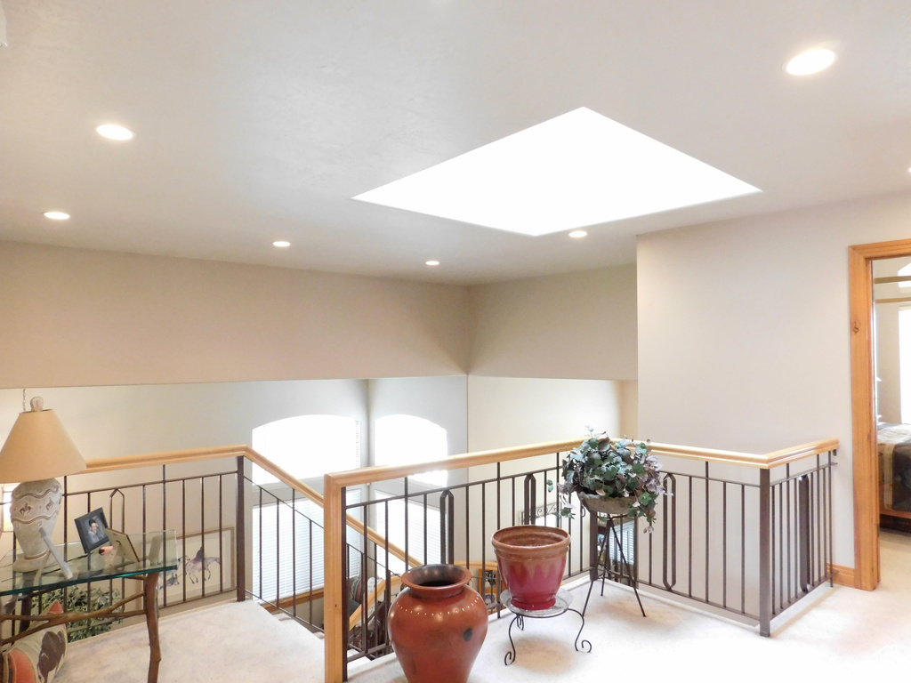 Hallway featuring carpet flooring, an upstairs landing, and recessed lighting