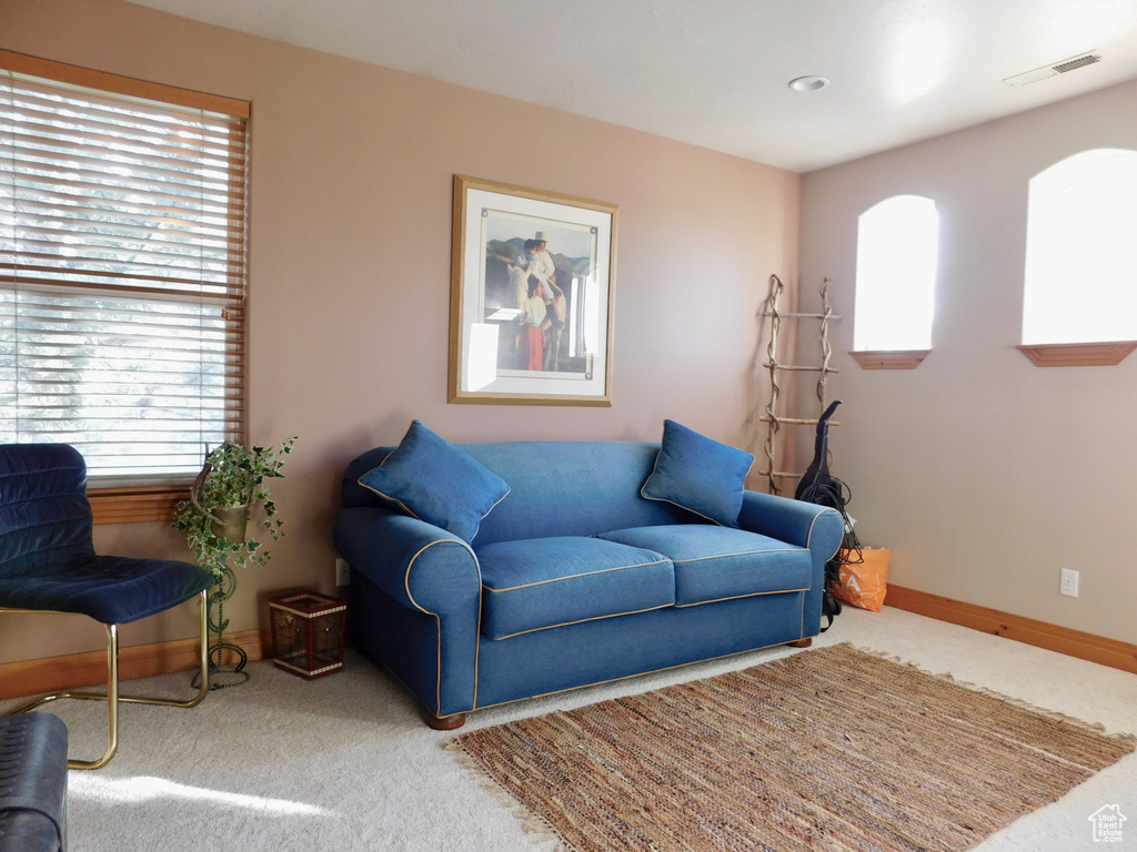 Carpeted living area featuring baseboards