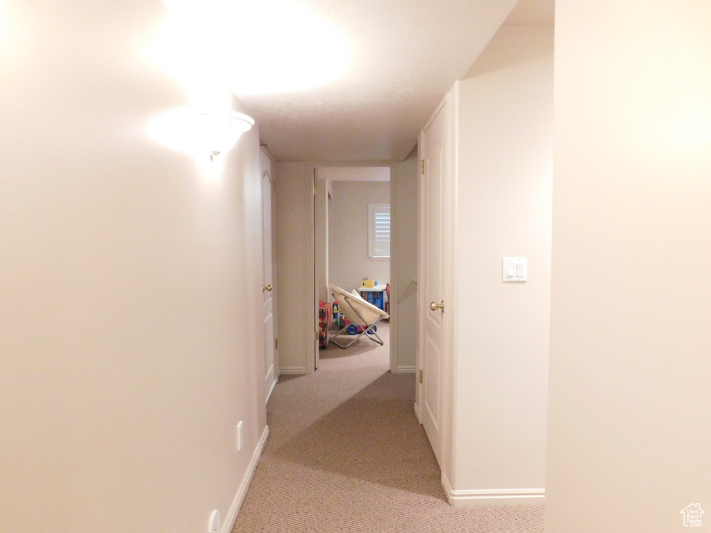 Hall with light carpet and baseboards