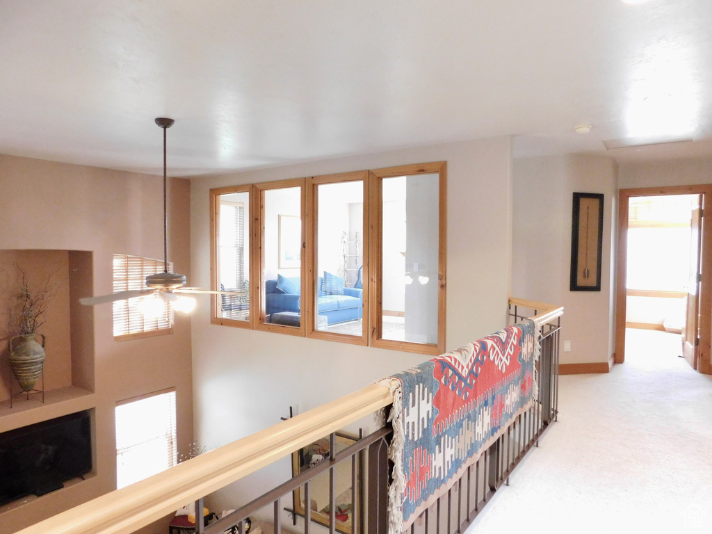 Hallway featuring an upstairs landing, carpet, and baseboards