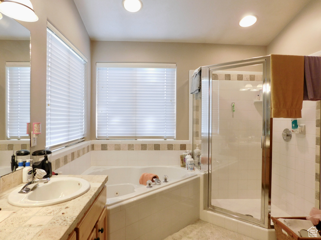 Bathroom with a jetted tub, vanity, a stall shower, and tile patterned floors