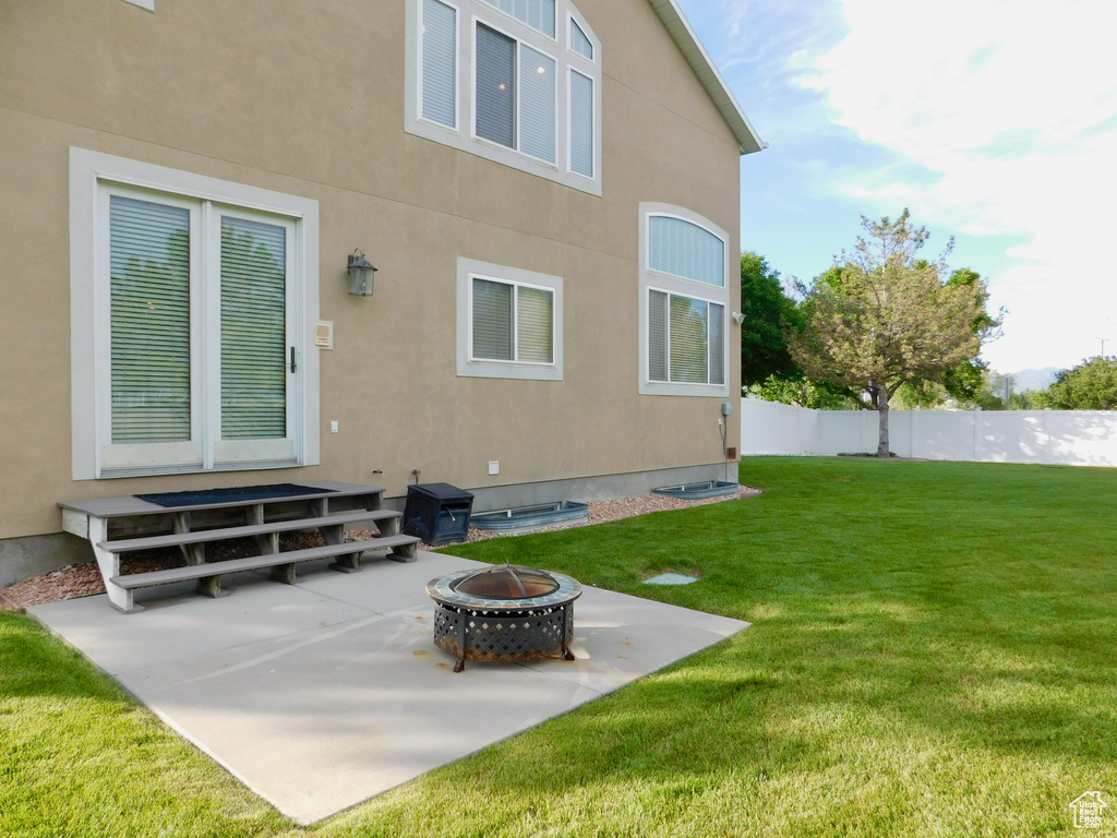Back of house with an outdoor fire pit, a patio area, and stucco siding