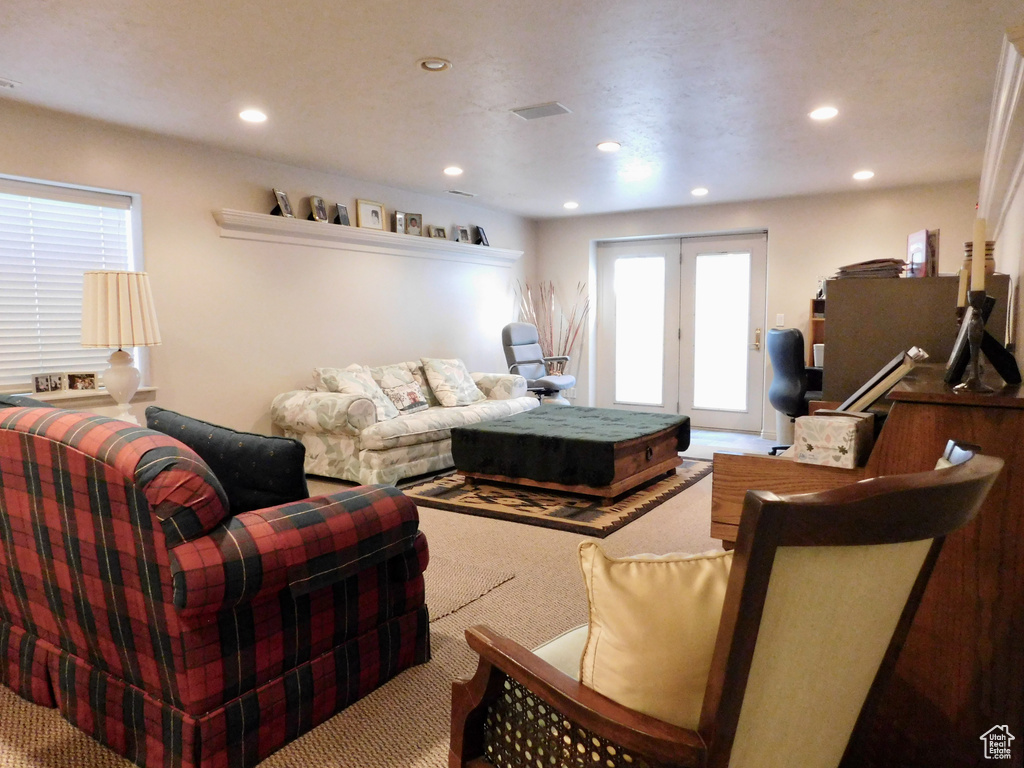 Carpeted living room featuring french doors and recessed lighting