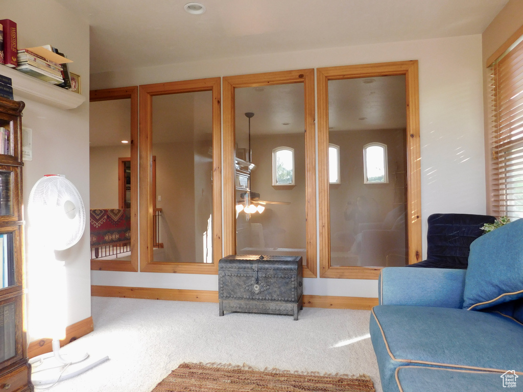 Living room featuring baseboards, carpet floors, and ceiling fan