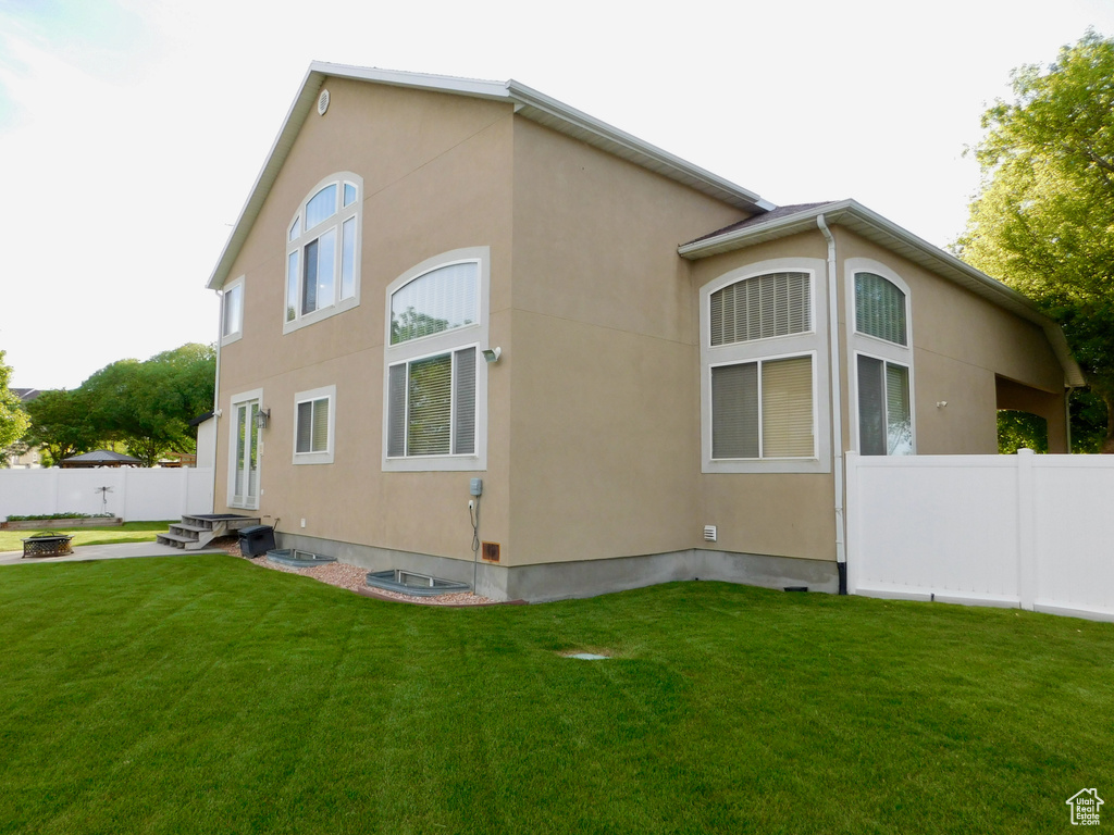 View of side of home featuring a fire pit and stucco siding