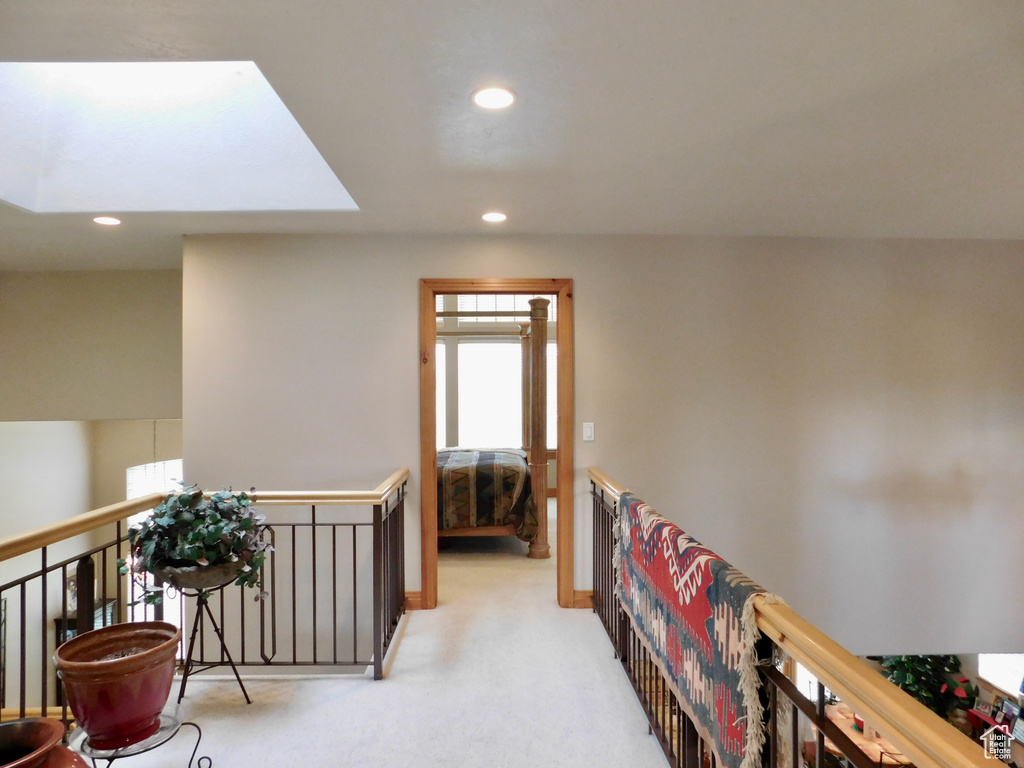 Hallway featuring recessed lighting, an upstairs landing, a skylight, and carpet flooring