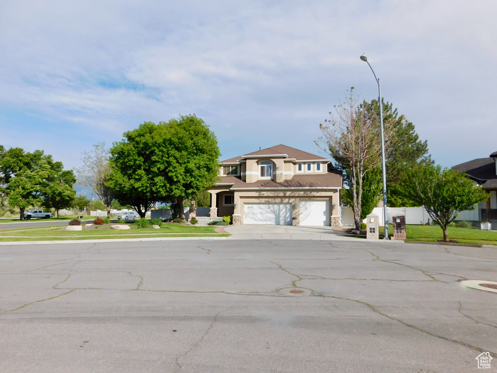 View of front of home featuring stucco siding, a garage, and concrete driveway