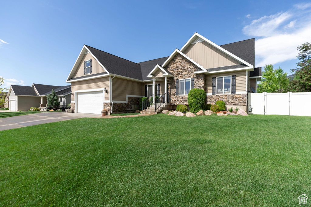 Craftsman house with stone siding, board and batten siding, driveway, and an attached garage