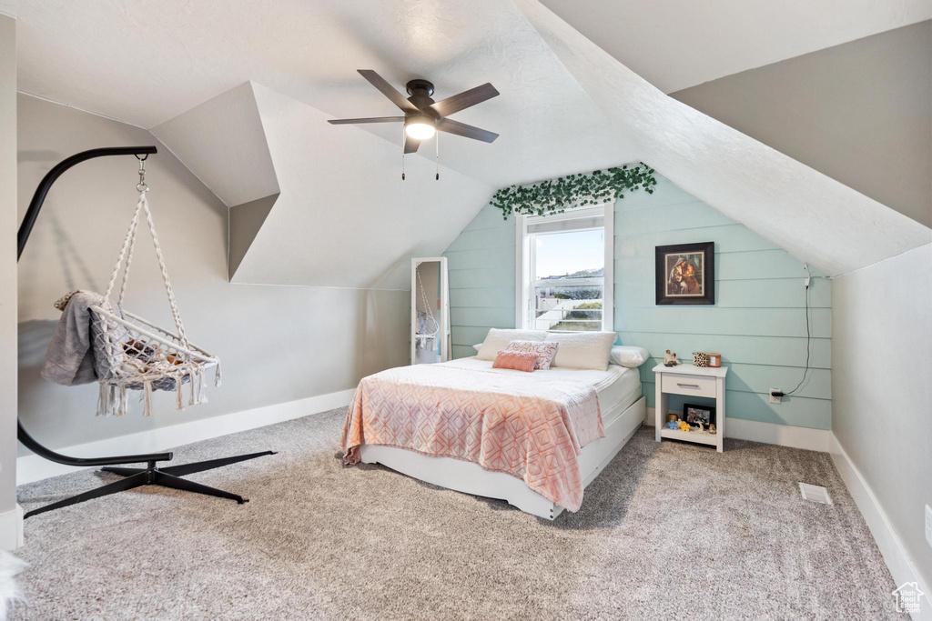 Carpeted bedroom with lofted ceiling, ceiling fan, and baseboards