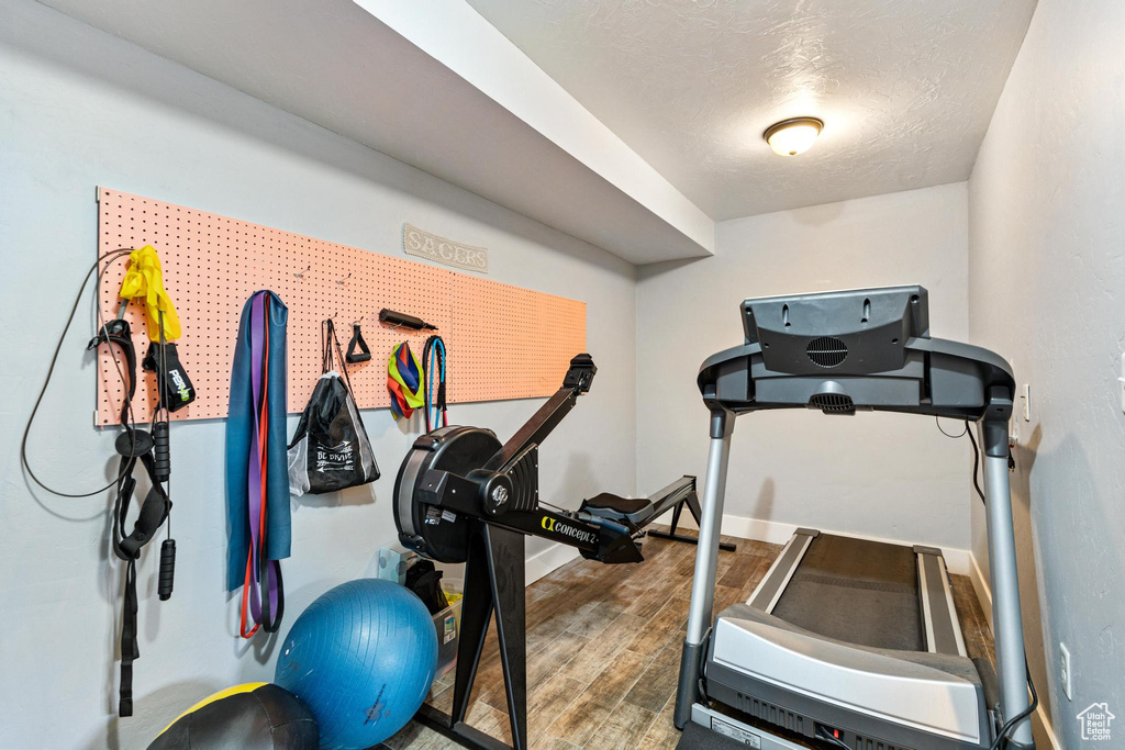 Exercise area with wood finished floors and baseboards