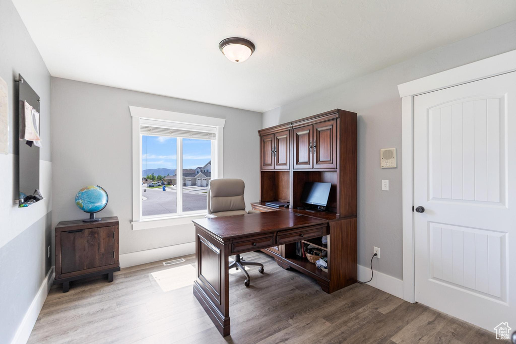 Office space featuring light wood-style flooring and baseboards