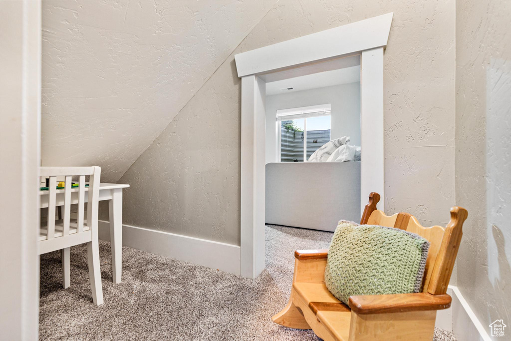 Carpeted bedroom with lofted ceiling, a textured wall, and a textured ceiling