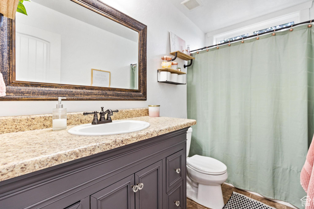 Bathroom with vanity, toilet, a shower with shower curtain, and tile patterned floors