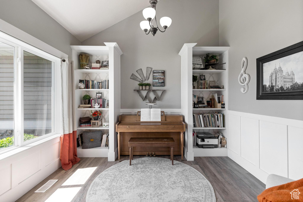 Sitting room featuring wood finished floors, vaulted ceiling, and wainscoting