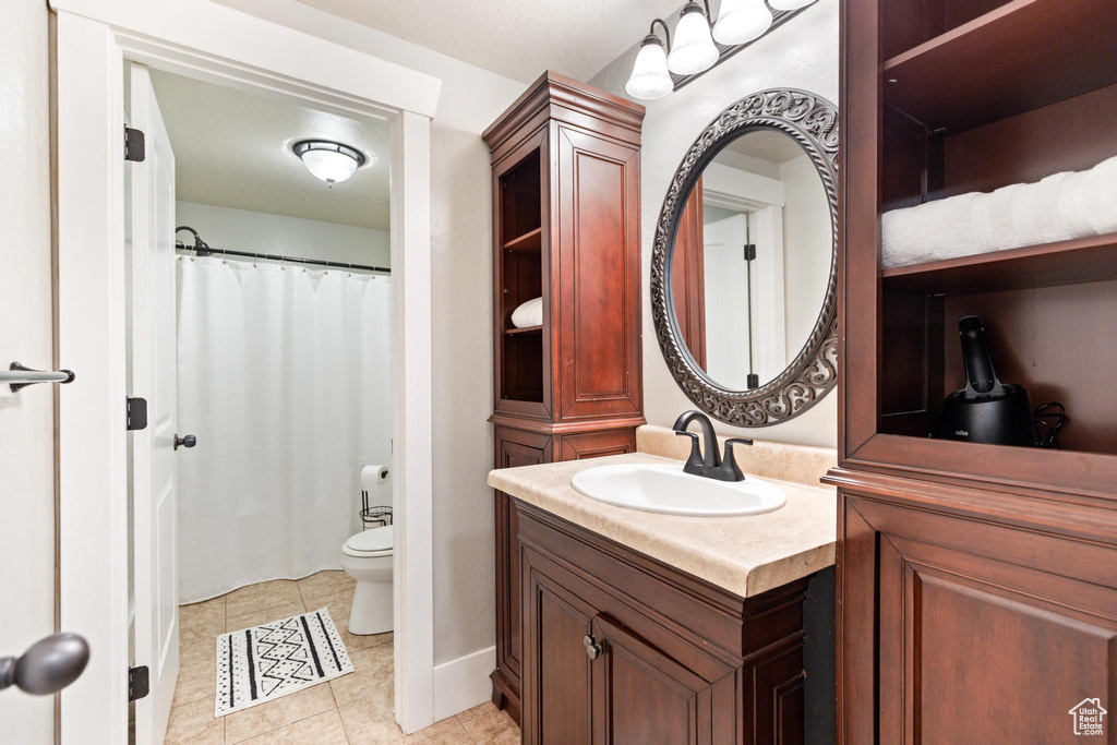 Full bath featuring vanity, toilet, tile patterned floors, and curtained shower