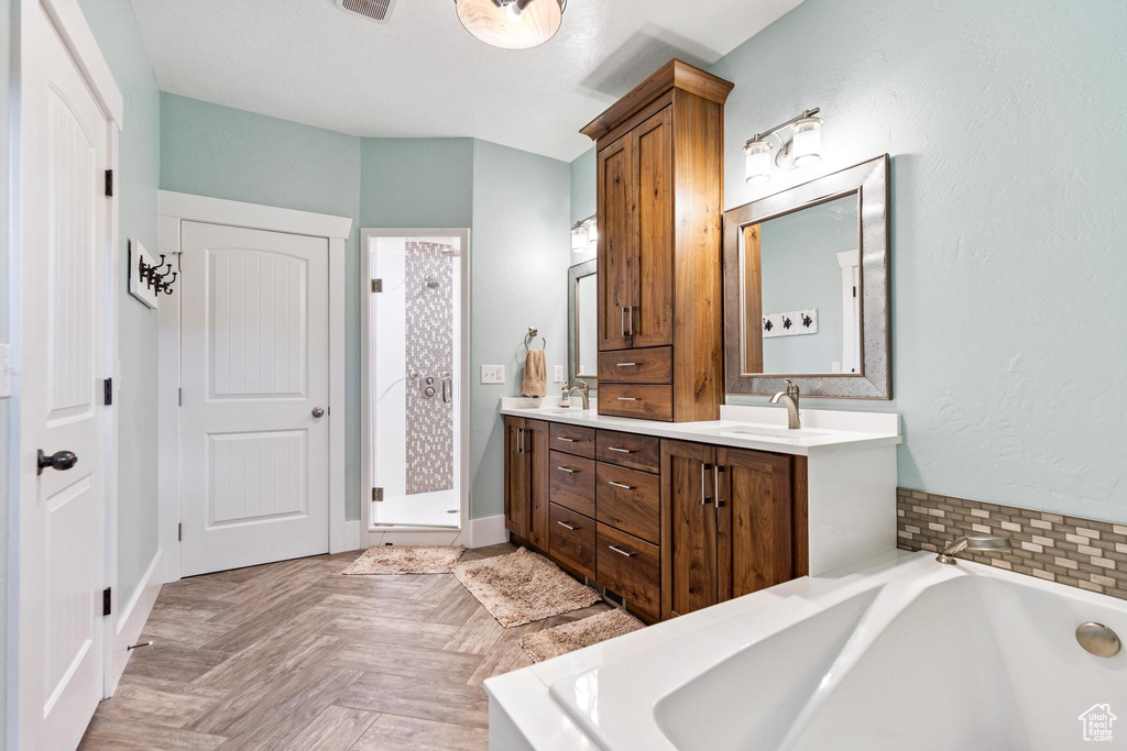 Bathroom with double vanity, a stall shower, and a bath