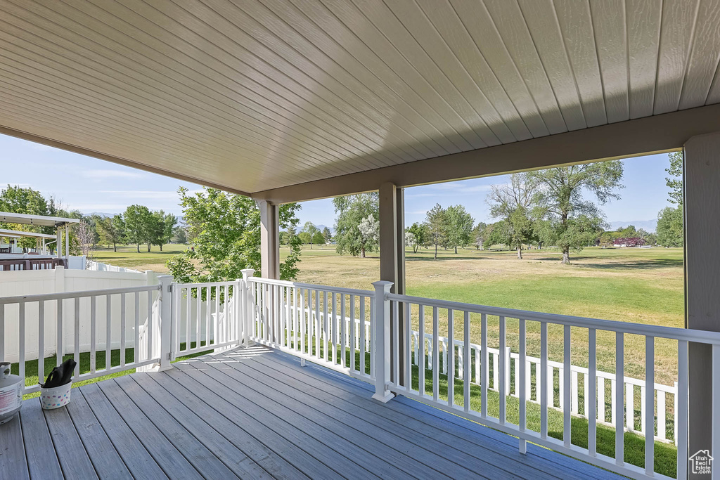 Deck with a lawn and view of scattered trees