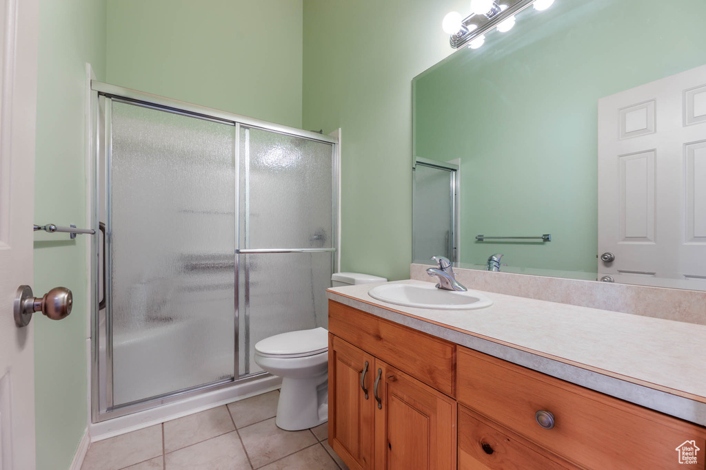 Bathroom featuring vanity, tile patterned floors, a shower stall, and toilet