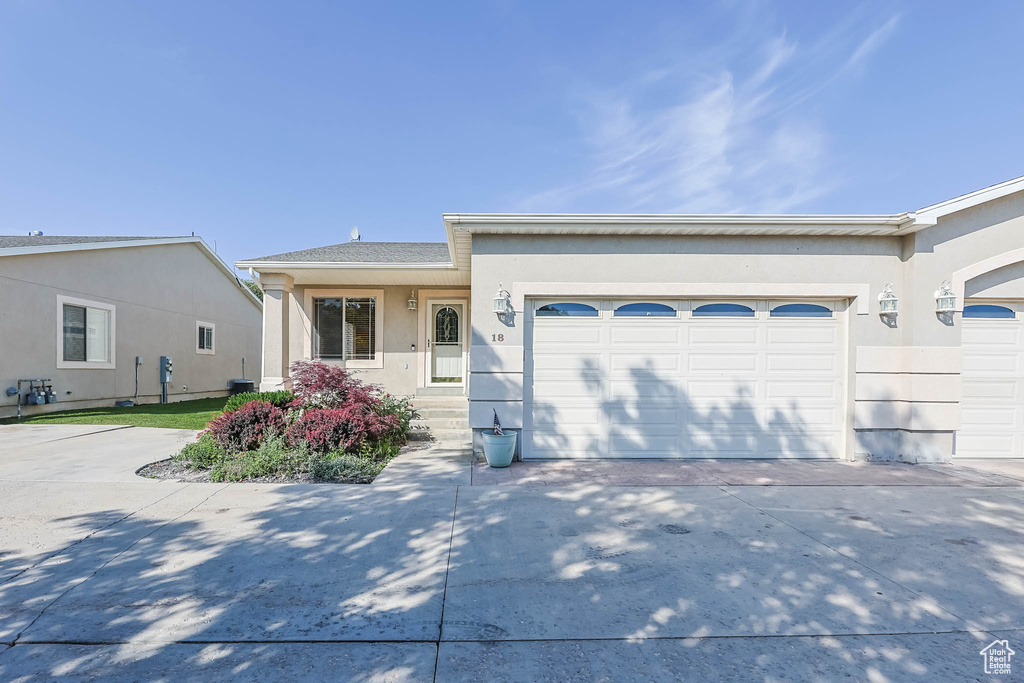 Single story home with a garage, concrete driveway, and stucco siding