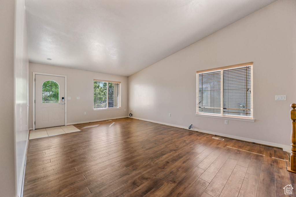 Foyer featuring hardwood / wood-style flooring, vaulted ceiling, and baseboards