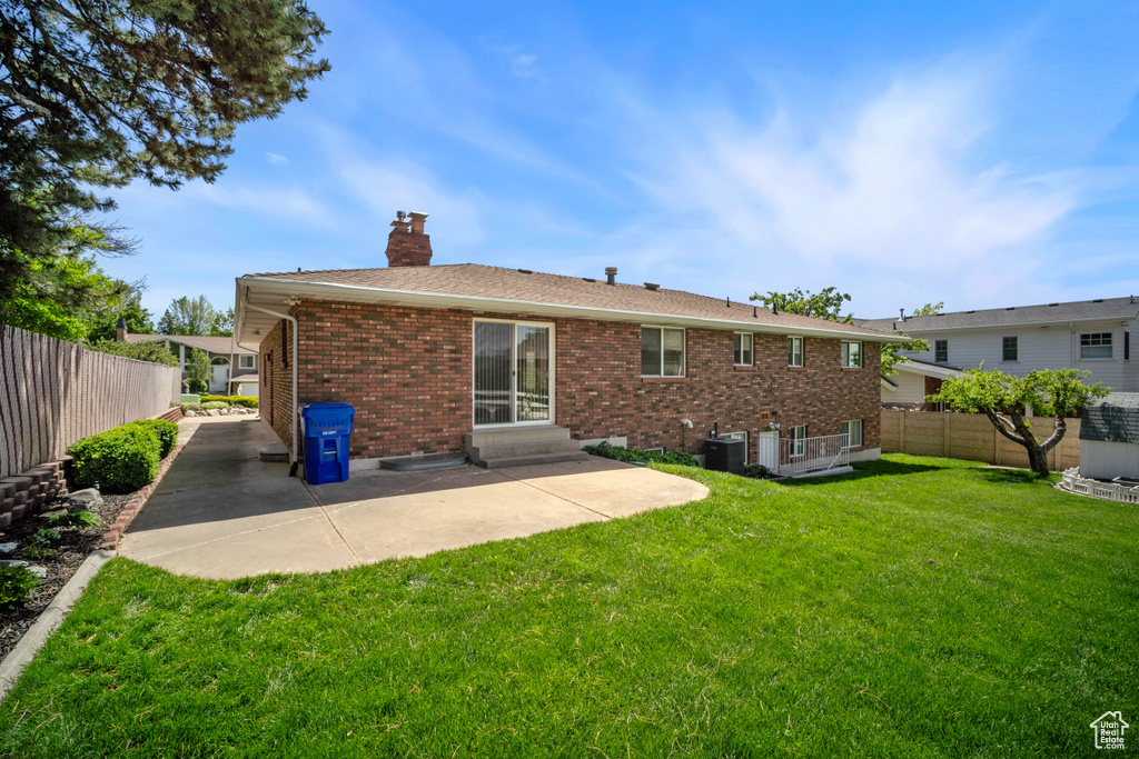 Back of house featuring a chimney, entry steps, brick siding, a patio area, and central air condition unit