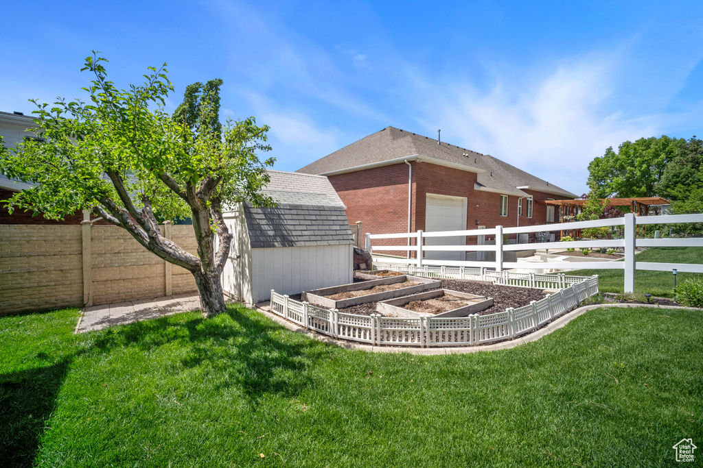 View of yard featuring a vegetable garden and an attached garage