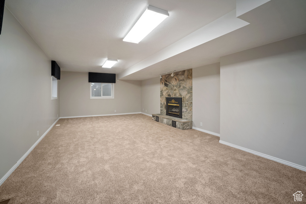 Finished basement with carpet, a fireplace, and baseboards