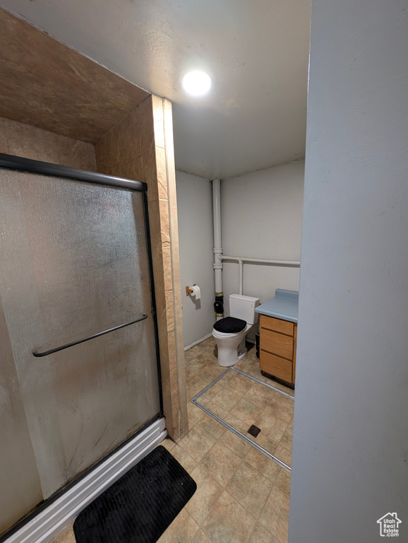Bathroom featuring a stall shower, toilet, and vanity