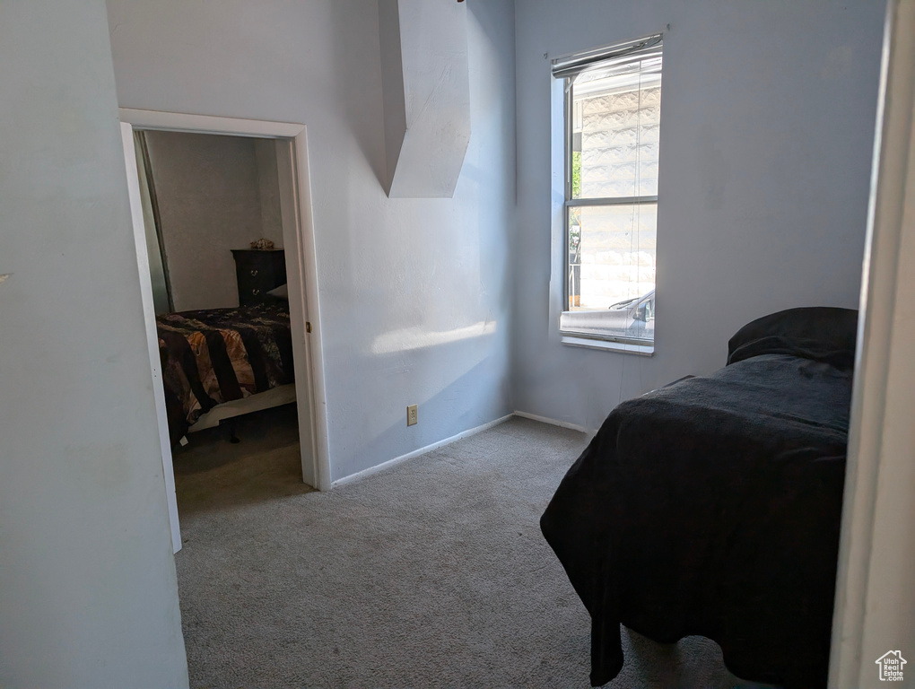 Bedroom featuring carpet and baseboards
