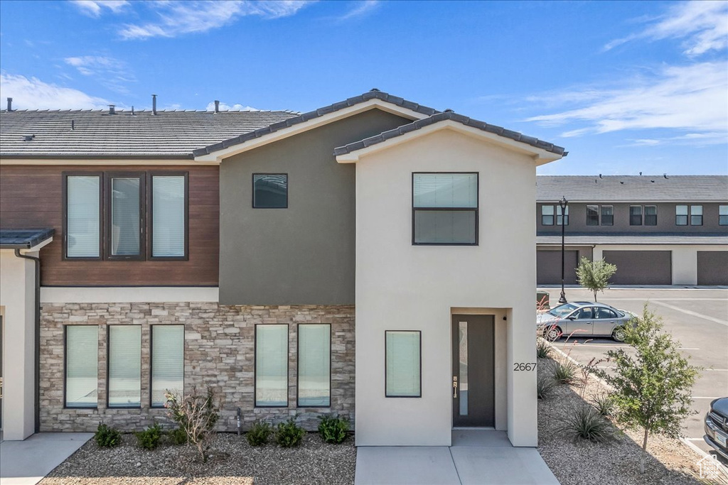 View of front of house with stone siding and stucco siding