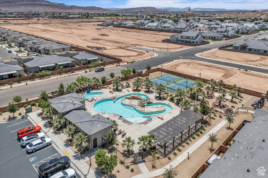 Aerial perspective of suburban area featuring a pool area and a mountainous background