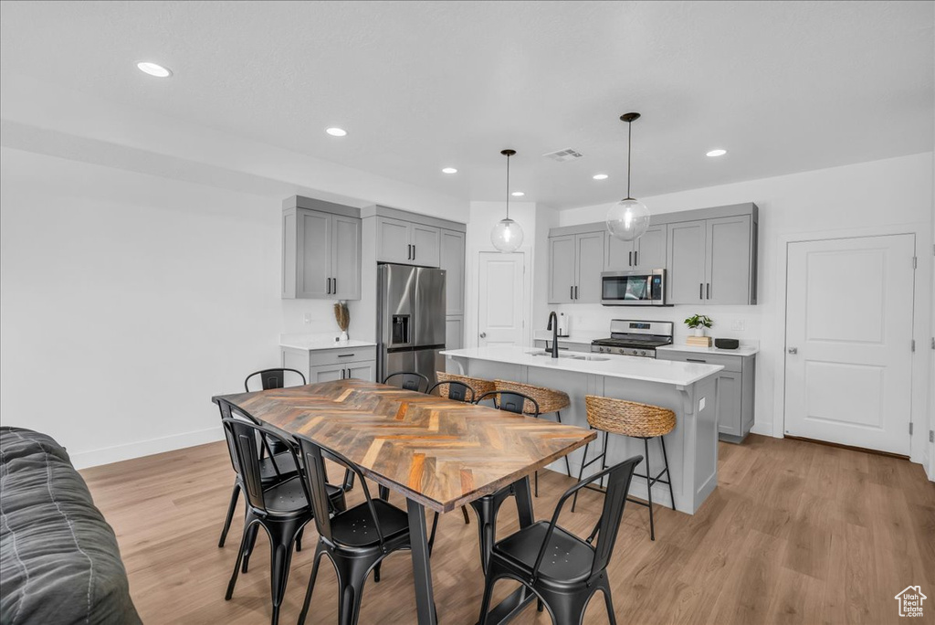 Dining area with light wood-style floors, baseboards, and recessed lighting