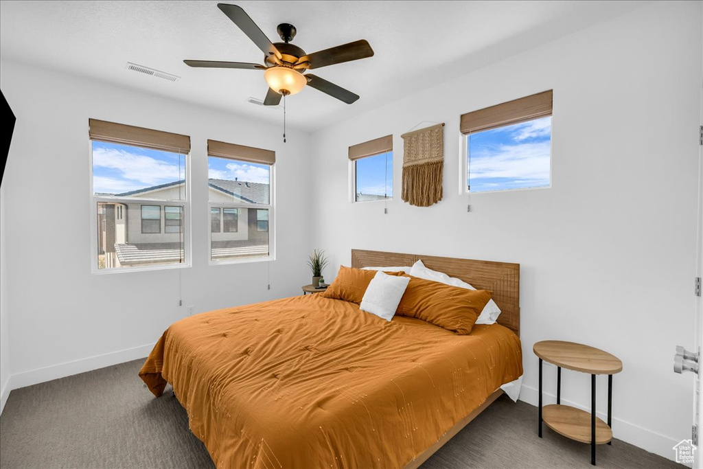 Carpeted bedroom with baseboards and a ceiling fan