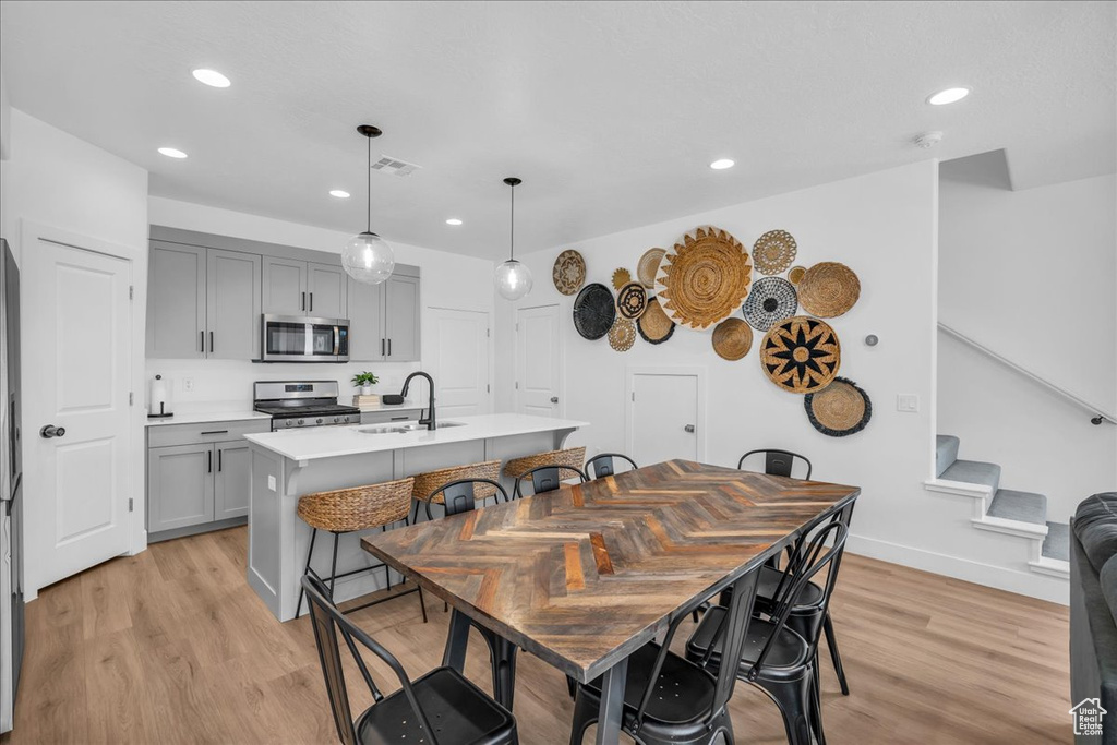 Dining area with light wood finished floors, stairway, recessed lighting, and baseboards