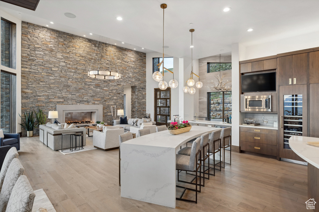 Kitchen with stainless steel microwave, recessed lighting, a kitchen bar, light wood-style floors, and modern cabinets