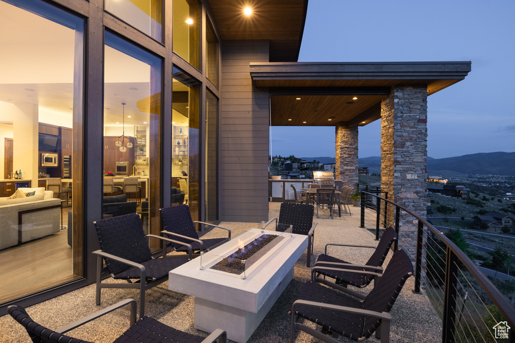 View of patio / terrace with a fire pit, a mountain view, and a balcony