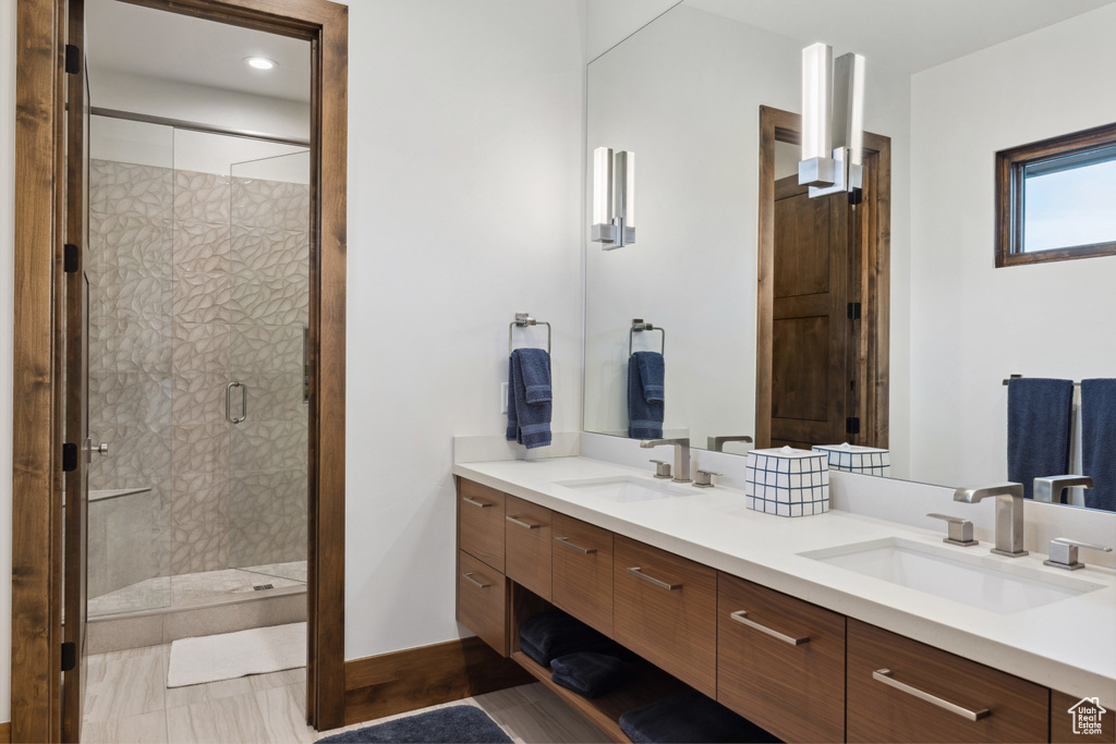 Full bathroom featuring double vanity and a shower stall