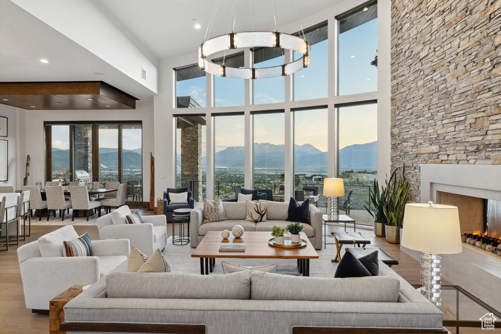 Living room with a mountain view, wood finished floors, healthy amount of natural light, recessed lighting, and a high ceiling