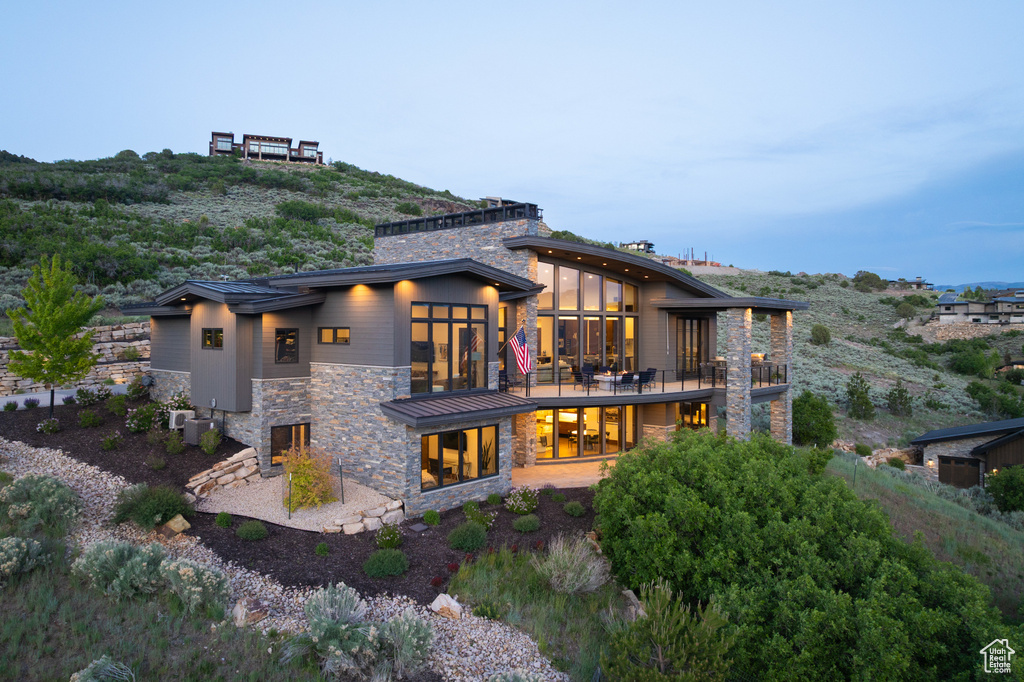 Back of property featuring stone siding and a chimney