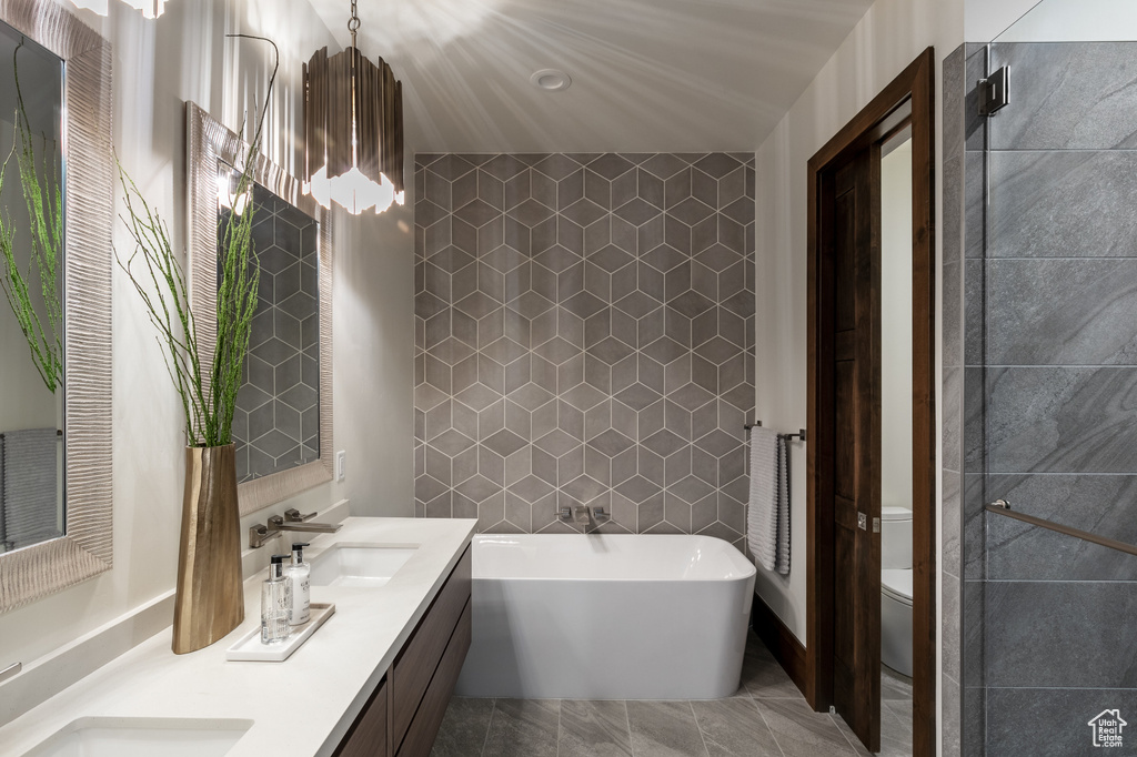 Full bath featuring a freestanding bath, double vanity, and toilet