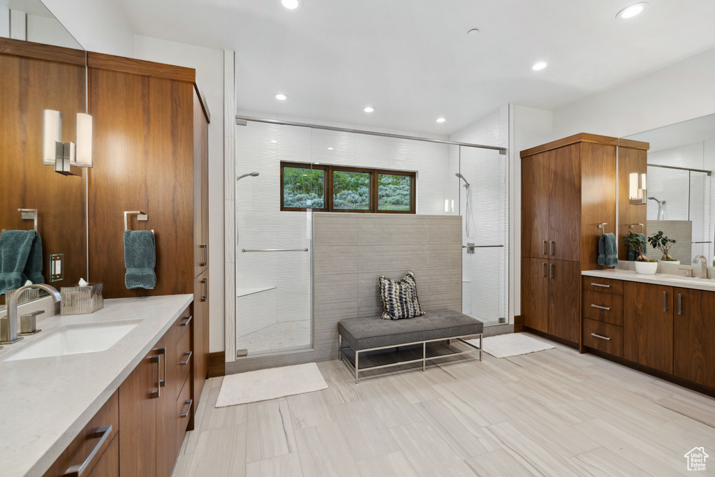 Full bath featuring a stall shower, two vanities, and recessed lighting