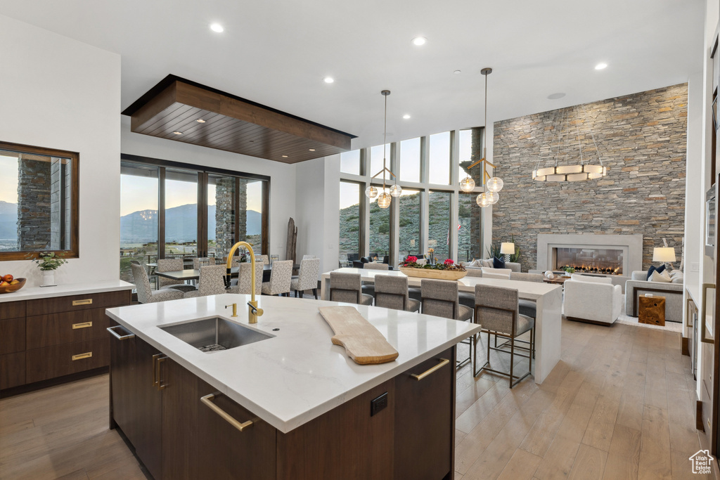 Kitchen with a sink, modern cabinets, open floor plan, an island with sink, and dark brown cabinetry