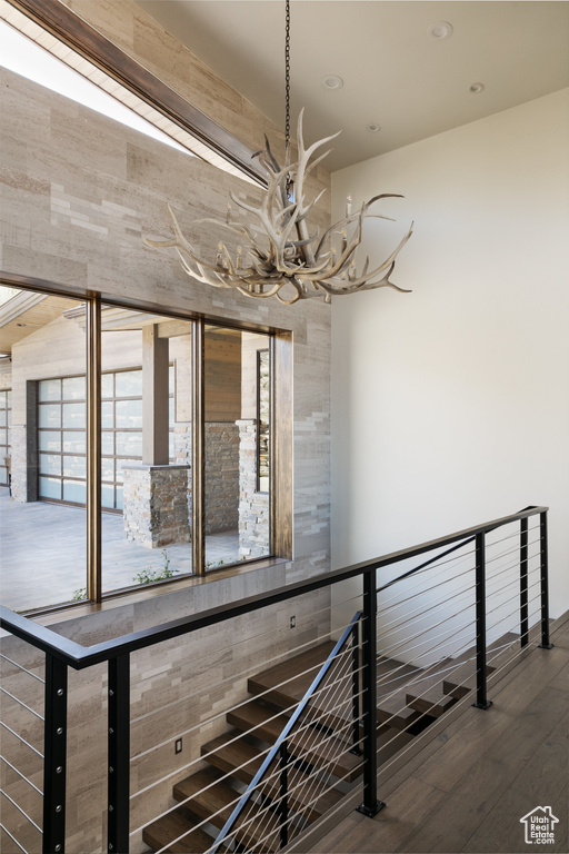 Stairway featuring a chandelier, wood finished floors, and recessed lighting
