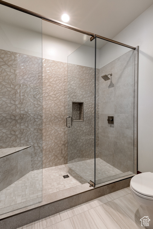 Bathroom with toilet, a stall shower, and recessed lighting