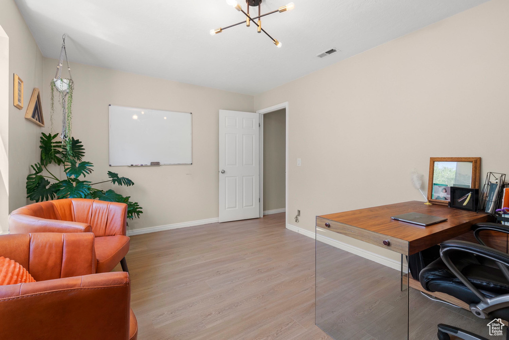 Office with a chandelier, light wood-type flooring, and baseboards