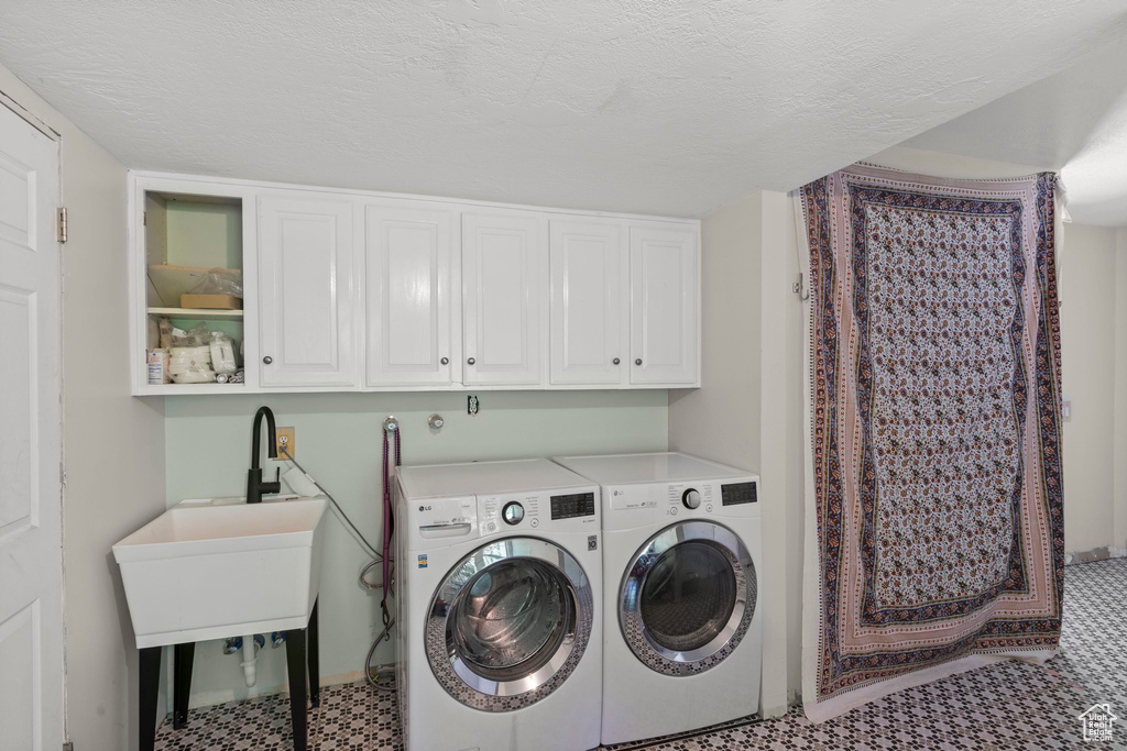 Laundry room with washer and clothes dryer and cabinet space