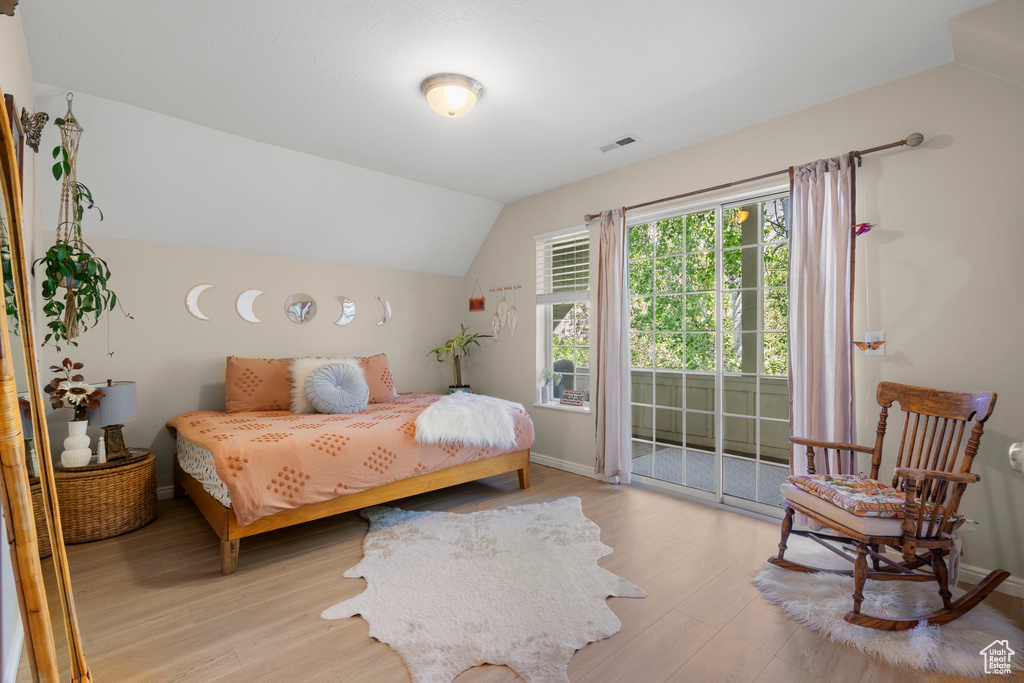 Bedroom with lofted ceiling, light wood-type flooring, access to outside, and baseboards